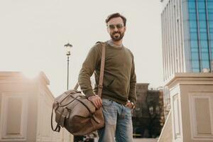 hipster man walking in street with bag photo