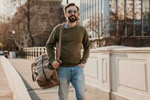 hipster hombre caminando en calle con bolso foto