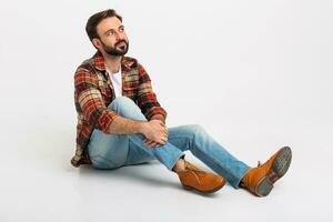 handsome bearded man in hipster outfit dressed in jeans and checkered shirt photo