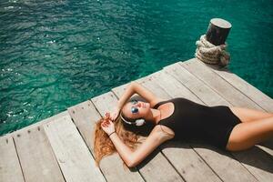 young slim woman laying on pier photo