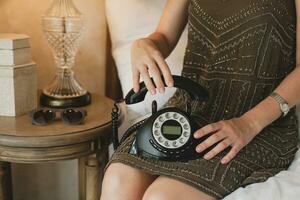 young beautiful woman sitting on bed in hotel room photo