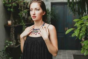 retrato de joven atractivo mujer en elegante negro vestir vistiendo lujo Rico collar joyería foto