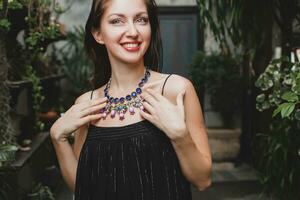 retrato de joven atractivo mujer en elegante negro vestir vistiendo lujo Rico collar joyería foto