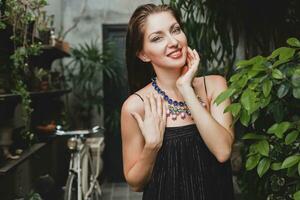 retrato de joven atractivo mujer en elegante negro vestir vistiendo lujo Rico collar joyería foto