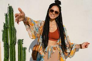 elegante bonito mujer con africano trenzas en soleado verano vacaciones foto