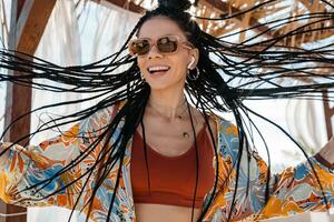 stylish pretty woman with african braids on sunny summer vacation photo