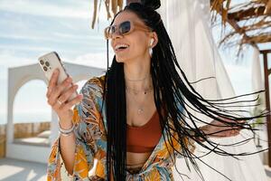 stylish pretty woman with african braids on sunny summer vacation photo