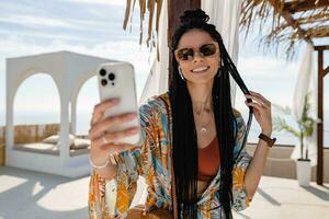 stylish pretty woman with african braids on sunny summer vacation photo