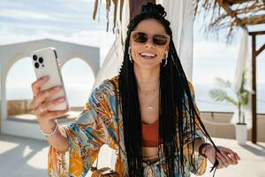 stylish pretty woman with african braids on sunny summer vacation photo