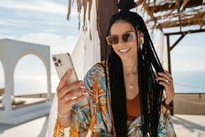 stylish pretty woman with african braids on sunny summer vacation photo