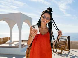 stylish pretty woman with african braids on sunny summer vacation photo