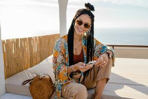 stylish pretty woman with african braids on sunny summer vacation photo