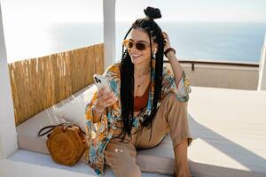 elegante bonito mujer con africano trenzas en soleado verano vacaciones foto