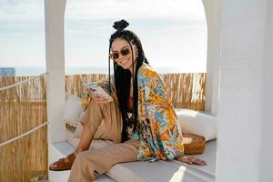 elegante bonito mujer con africano trenzas en soleado verano vacaciones foto