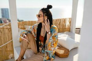 stylish pretty woman with african braids on sunny summer vacation photo