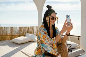 stylish pretty woman with african braids on sunny summer vacation photo