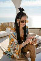 stylish pretty woman with african braids on sunny summer vacation photo