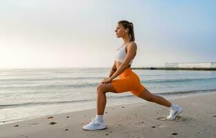 bonito joven sonriente mujer haciendo Deportes en el Mañana en elegante deporte atuendo ropa de deporte, flaco fuerte cuerpo, sano ajuste estilo de vida foto