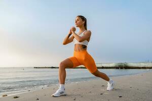 bonito joven sonriente mujer haciendo Deportes en el Mañana en elegante deporte atuendo ropa de deporte, flaco fuerte cuerpo, sano ajuste estilo de vida foto