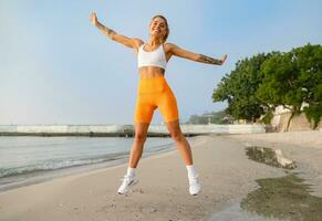 pretty young smiling woman doing sports in the morning in stylish sport outfit sportswear, skinny strong body, healthy fit lifestyle photo