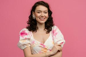 pretty young woman posing isolated on pink studio background in dress photo