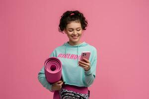 smiling happy beautiful woman in stylish sports outfit posing on pink background isolated in studio photo