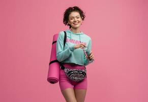 smiling happy beautiful woman in stylish sports outfit posing on pink background isolated in studio photo