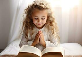 Cute child girl reading bible book. Worship at home. photo
