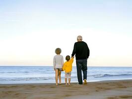 Grandfather walking with grandchildren at beach. Concept of grandfather day, grandparents day photo