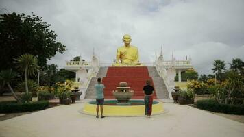 asiatisch Paare beten im Vorderseite von groß Buddha Statue video