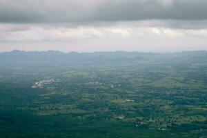 Big green mountains and lots of trees in the mountains. clouds floating on the mountain photo