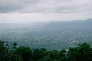 Big green mountains and lots of trees in the mountains. clouds floating on the mountain photo