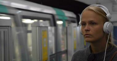 Urban woman listening to music in underground video