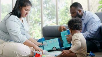 Happy Parents playing with a little infant toddler child on living room sofa. Parent and little kid relaxing at home. Parents and toddler child girl enjoying spending time at home. Childcare concept video