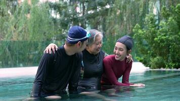 Senior Frau im aqua und Umarmung jung Trainer nach Aerobic und Arbeiten aus im das Schwimmbad. alt Frau tun aqua Aerobic Übung im das Schwimmen Schwimmbad, Alten Sport, und aktiv Lebensstil Konzept. video