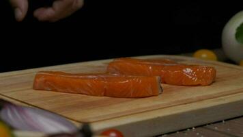 professionale capocuoco prepara rosso pesce bistecca per frittura. vicino su lento movimento. video