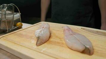 profesional cocinero prepara blanco pescado filete para fritura. cerca arriba lento movimiento. video