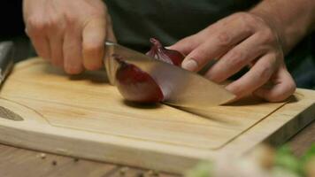 profesional cocinero prepara y cortes rojo cebolla. cerca arriba lento movimiento video