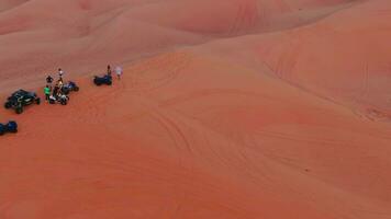drone mouches plus de une Jeune couple permanent sur une le sable dune dans le désert de le uni arabe émirats video