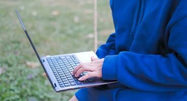 Woman relaxing with laptop in garden Suitable for making infographics. photo