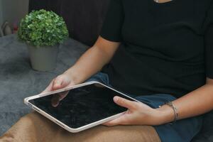 Woman's hand operating a tablet Suitable for making infographics. photo