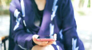 Woman relaxing with mobile phone in garden Suitable for making infographics. photo