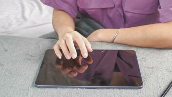 Woman's hand operating a tablet Suitable for making infographics. photo