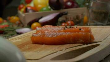 profissional chefe de cozinha granulados vermelho peixe bife com Pimenta. fechar acima lento movimento video
