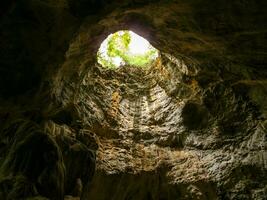 The vent inside the cave looked through until he could see the sky outside photo