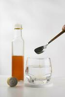 Mixing apple cider vinegar with drinking water for health benefits. photo