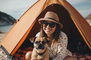 Happy young woman is sitting with her dog by a tourist tent on the beach. Traveling with pets concept. AI generated. photo