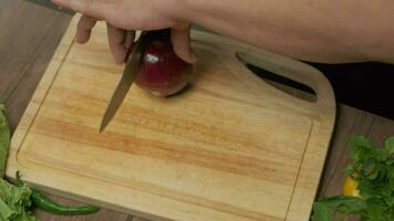 Professional chef prepares and cuts red onion. Close up slow motion video