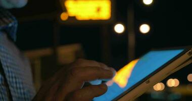 Man working with touch pad on bus stop at night video