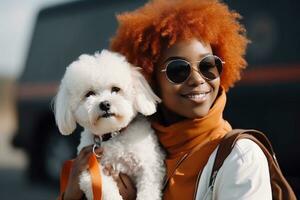 Happy young African American woman is holding her Bichon Frise dog on her hands and walking in the street. AI generated. photo